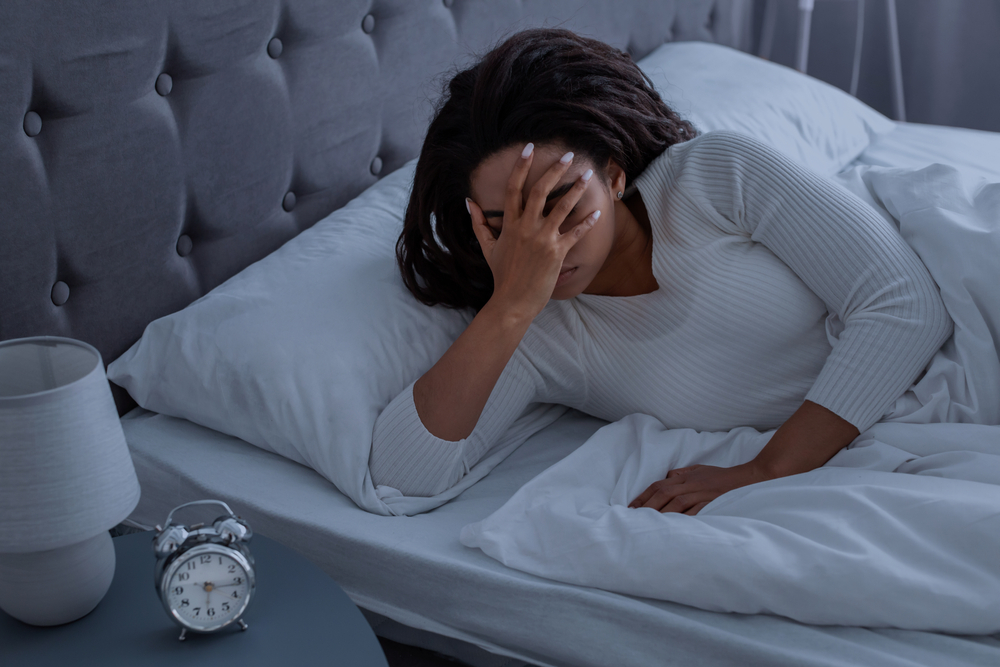 Substance abuse detoxification and mood stabilization influenced by sleep deprivation illustrated by stressed African American woman suffering from insomnia