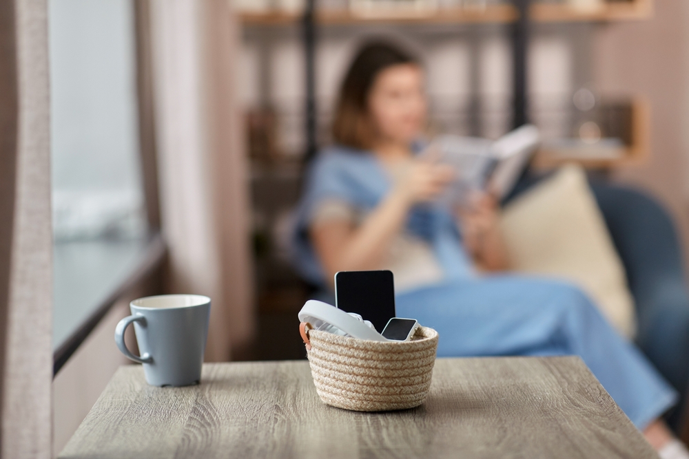 Embrace digital detox to alleviate mental repercussions and enrich interpersonal relationships with gadgets stowed away and a woman engrossed in reading a book